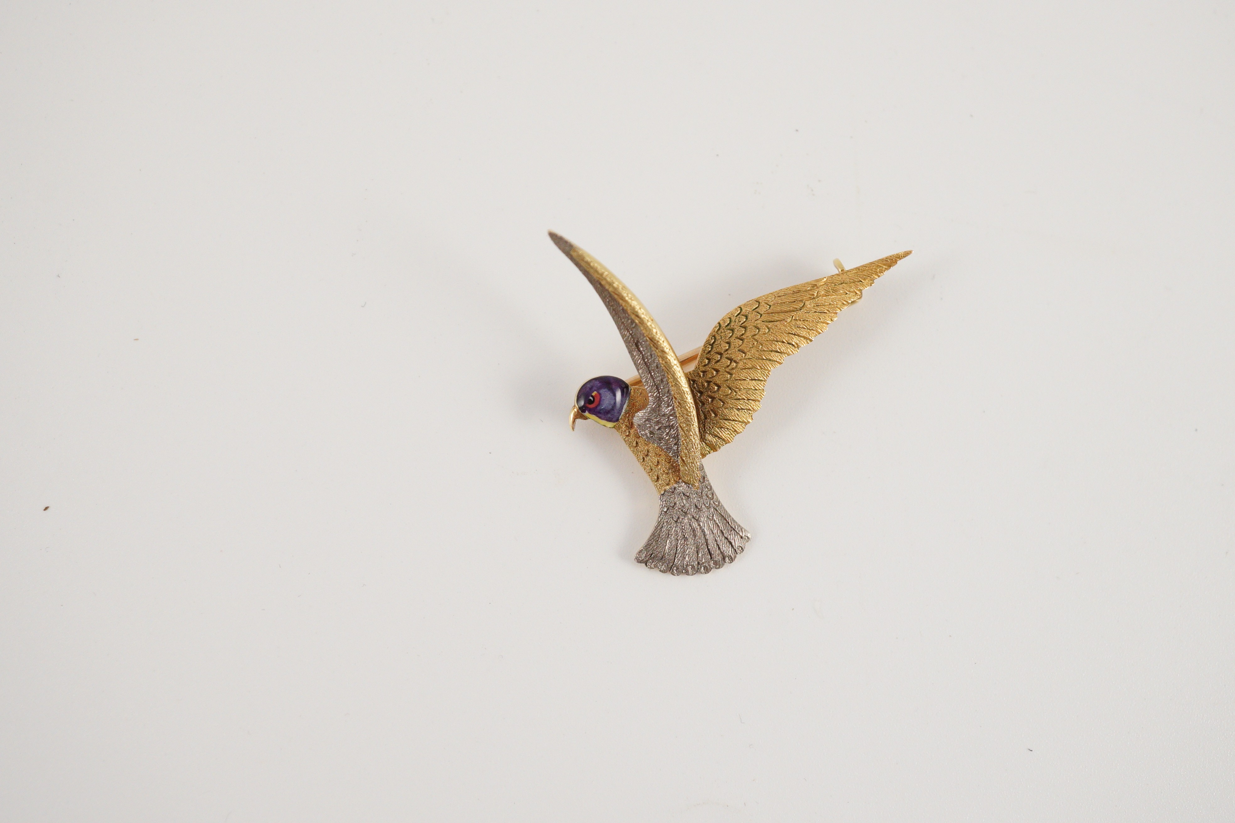 An early 20th century two colour 18ct gold, 15ct gold and enamel set brooch, modelled as a bird of prey
